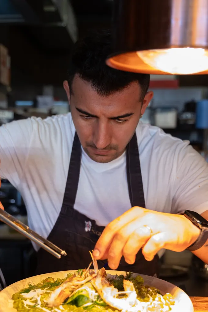 Chef Concas finishing a plate at the pass