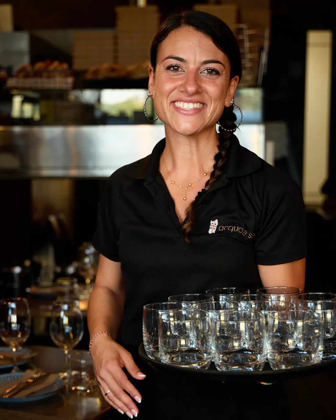 Front of house carrying a tray of glasses to the floor