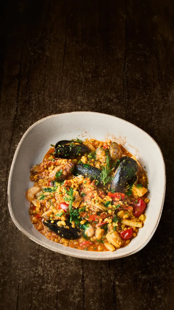 Seafood with mussels, clams and prawns served on a dark wooden table