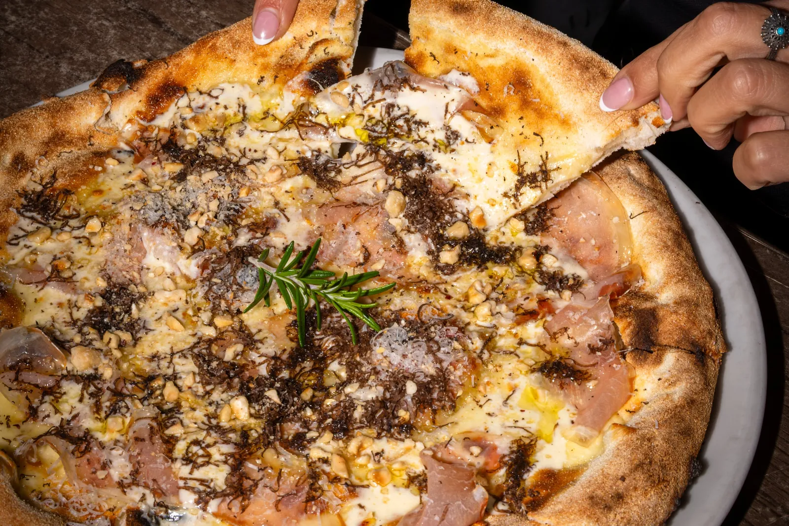 A slice lifted from a truffle and porchetta pizza