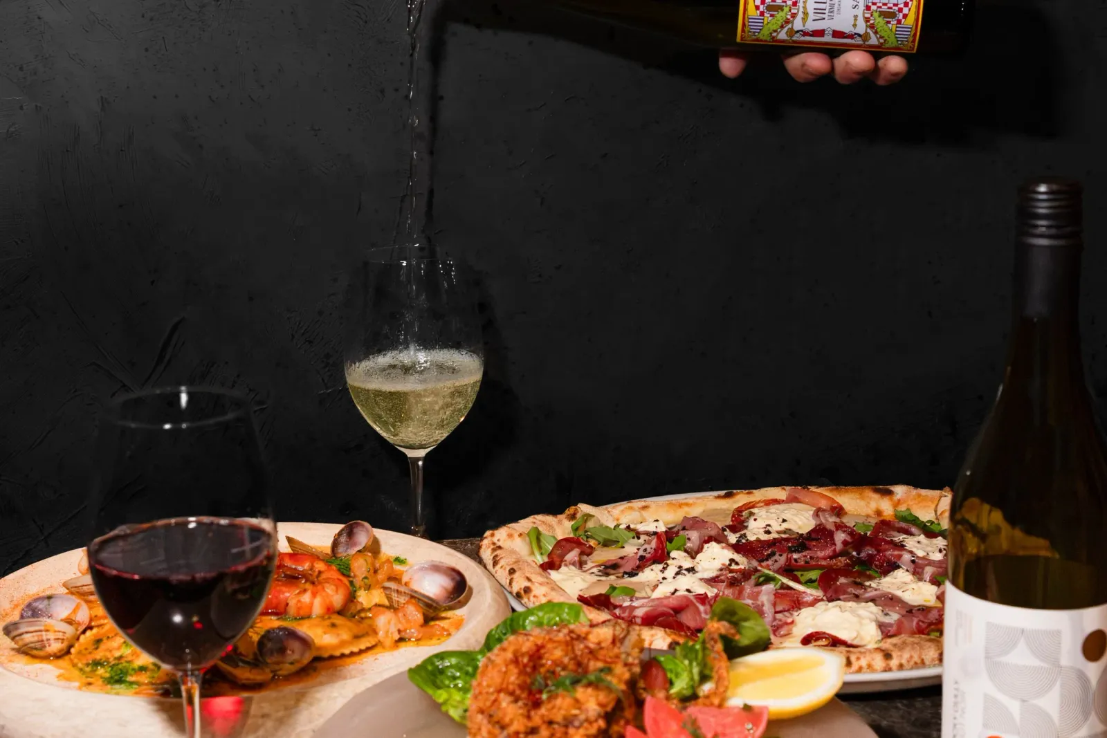 White wine poured above Sardinian seafood dishes and pizza